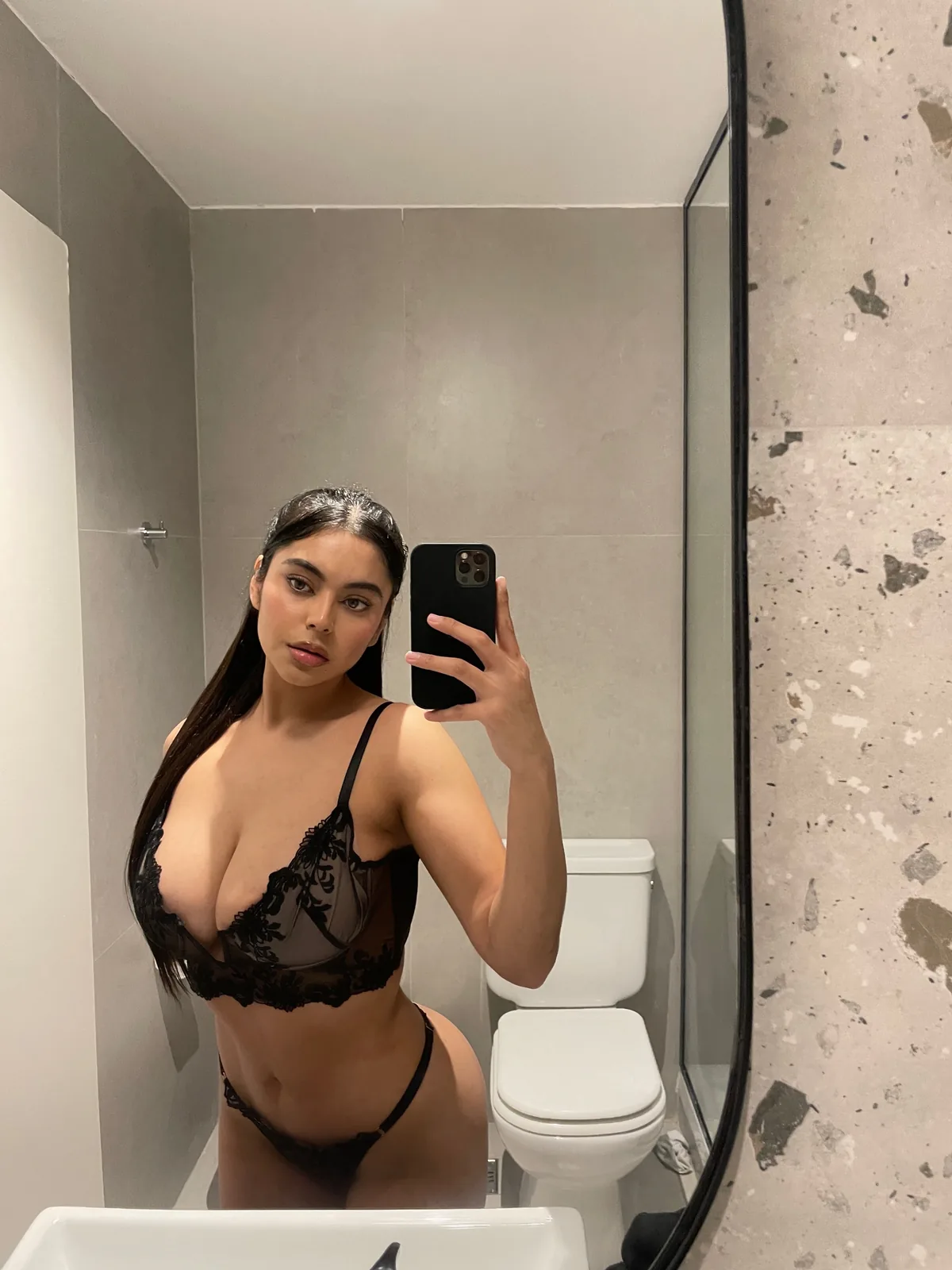 Angelina taking a mirror selfie in black lace